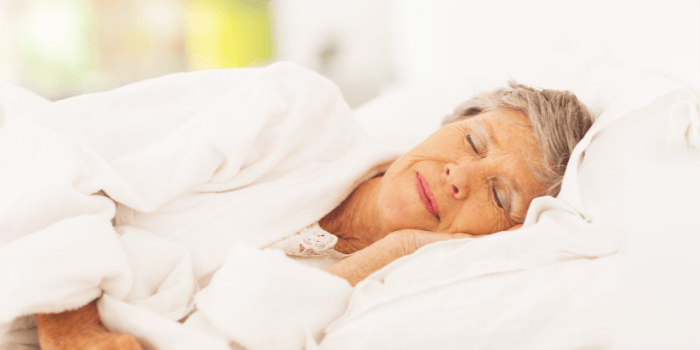 A woman with arthritis sleeping in bed.