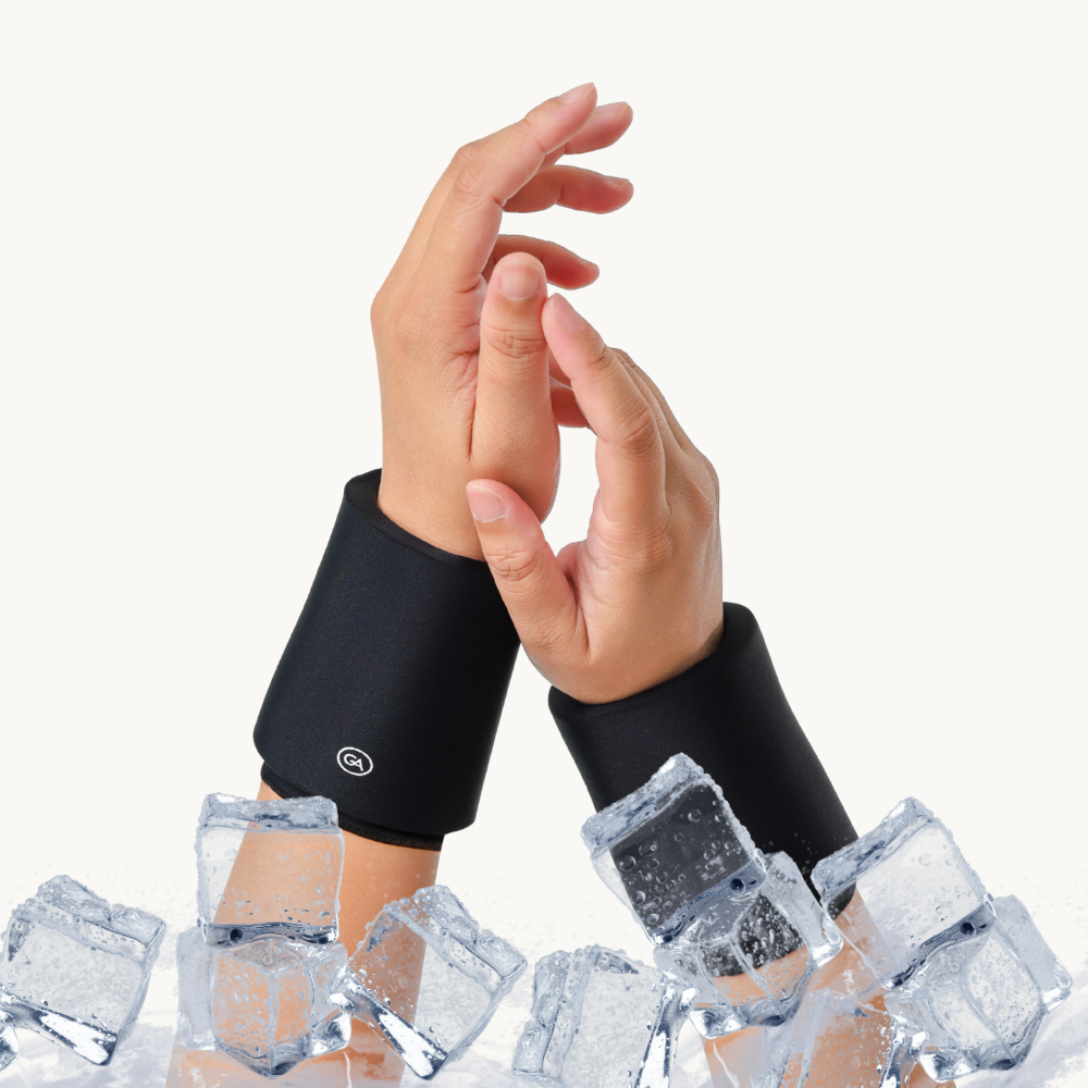 Two hands wearing jet black cooling compression sleeves for wrist posed above clear ice cubes against a plain white background.
