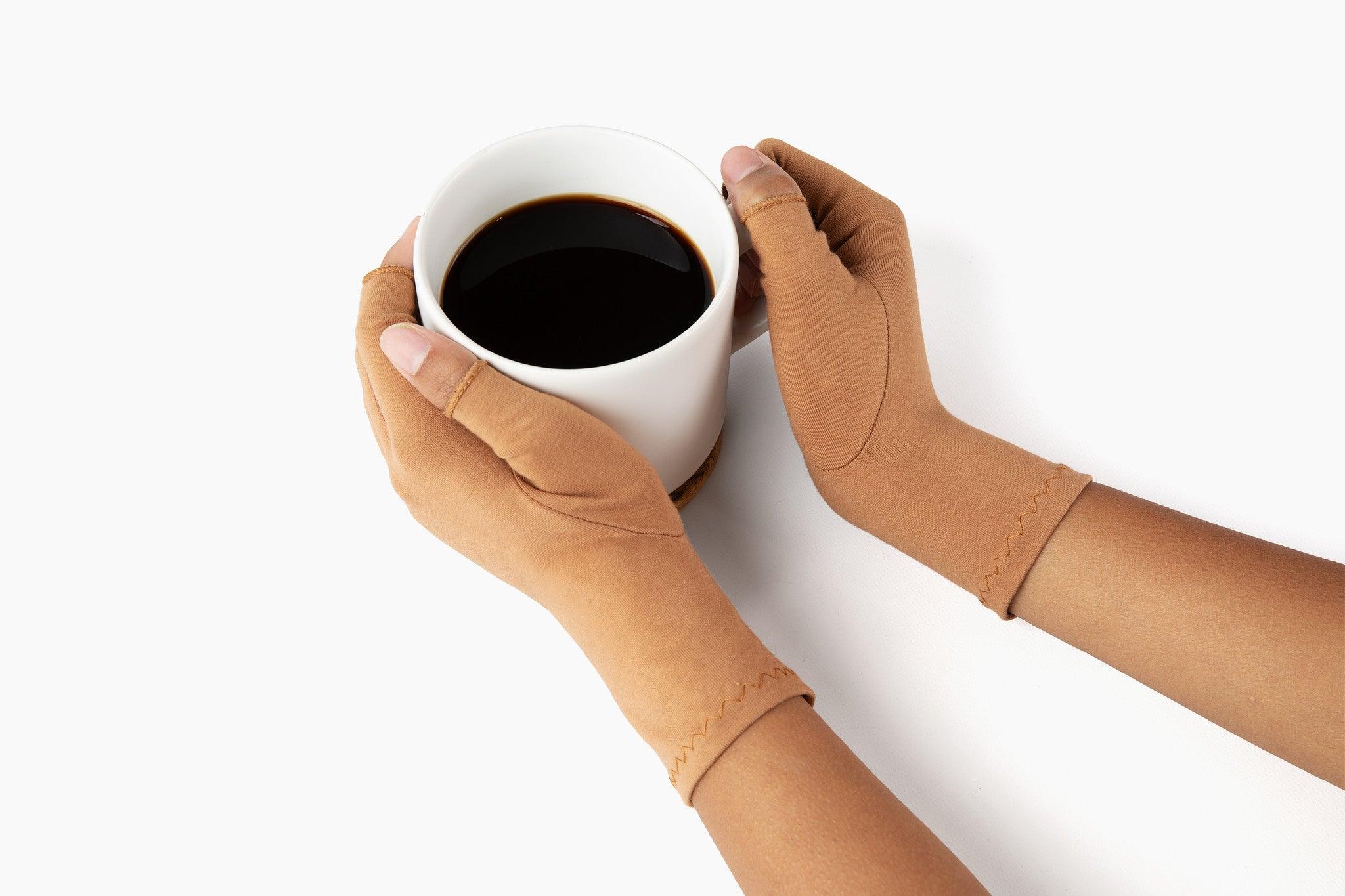 Cinnamon Brown Compression Gloves on a woman's hands holding a cup of coffee