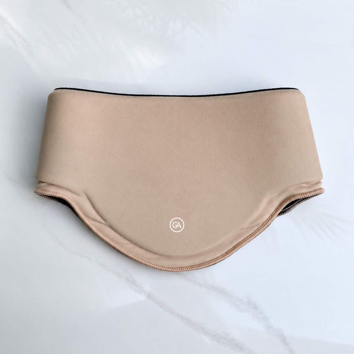 A latte beige cooling neck wrap, laid flat on a light marble-like surface.