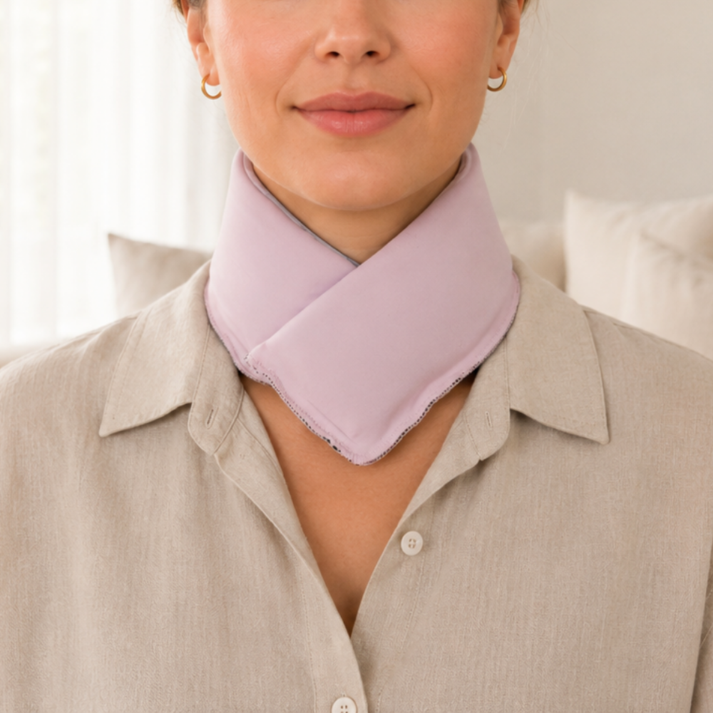 Woman wearing a pastel pink cooling neck wrap against a neutral background