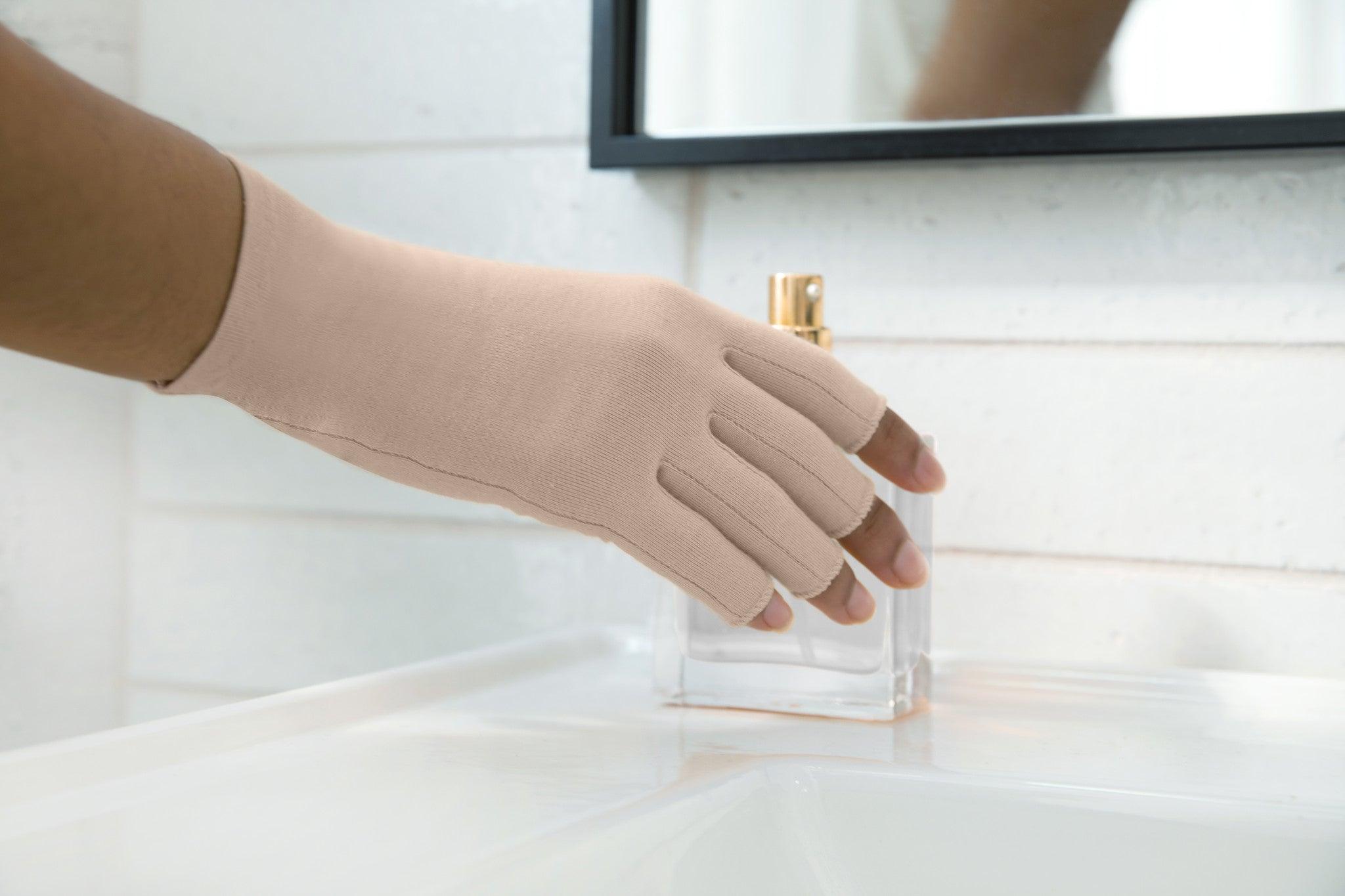 Sandy Beige Compression Gloves on a woman's hand holding a perfume bottle