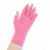 A close up of the hand of a woman with arthritis, wearing Coral Pink Compression Gloves and showing the palm of her hand.