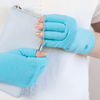 an arthritis patient a woman is wearing teal blue turquoise compression gloves for her hand pain and wrist pain