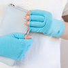 an arthritis patient a woman is wearing teal blue turquoise compression gloves for her hand pain and wrist pain