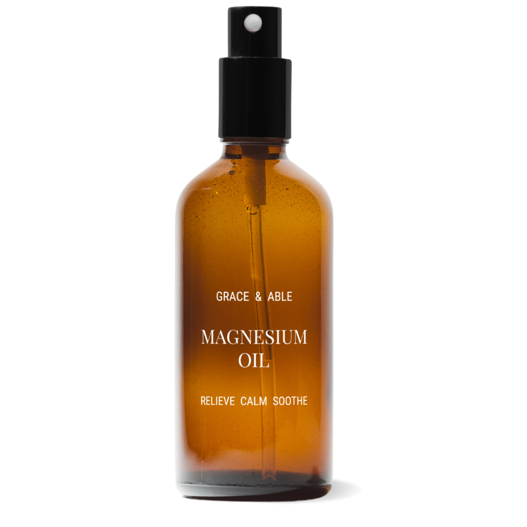 An amber bottle with white lettering that says 'Grace & Able Magnesium Oil Relieve Calm Soothe'.