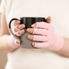 Load image into Gallery viewer, Close-up of the hands of a woman with arthritis, wearing Ballet Pink Compression Gloves, and holding a mug of turmeric tea