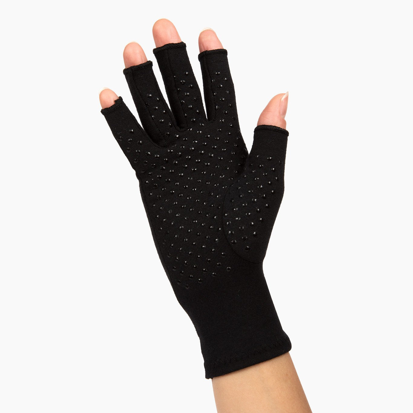 classic black compression gloves with silicone dots on palm worn by a hand with arthritis waving on a white background