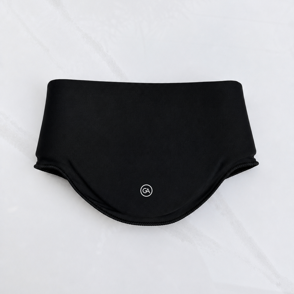 A jet black cooling neck wrap laid flat on a light gray marble-textured background.