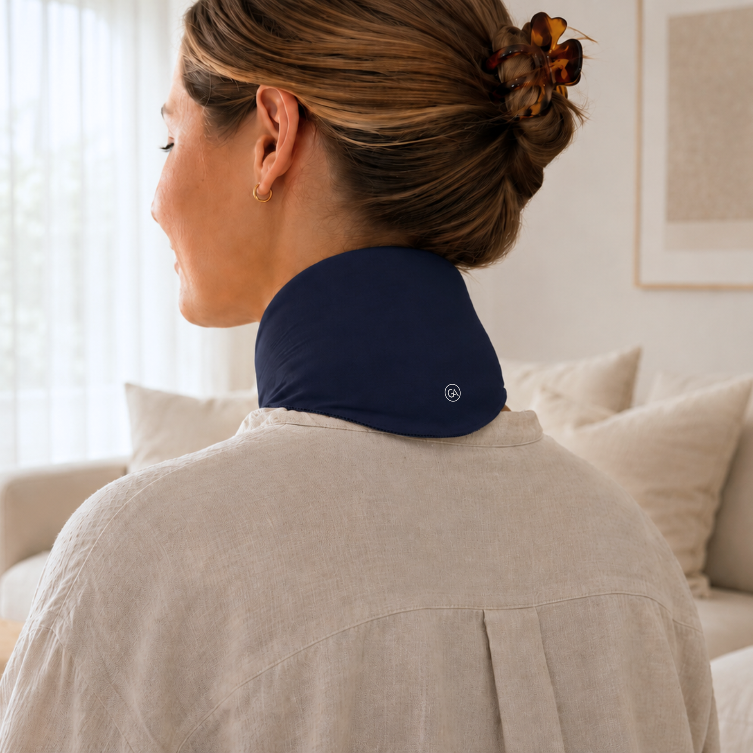 Woman wearing a midnight blue cooling neck wrap in a living room setting