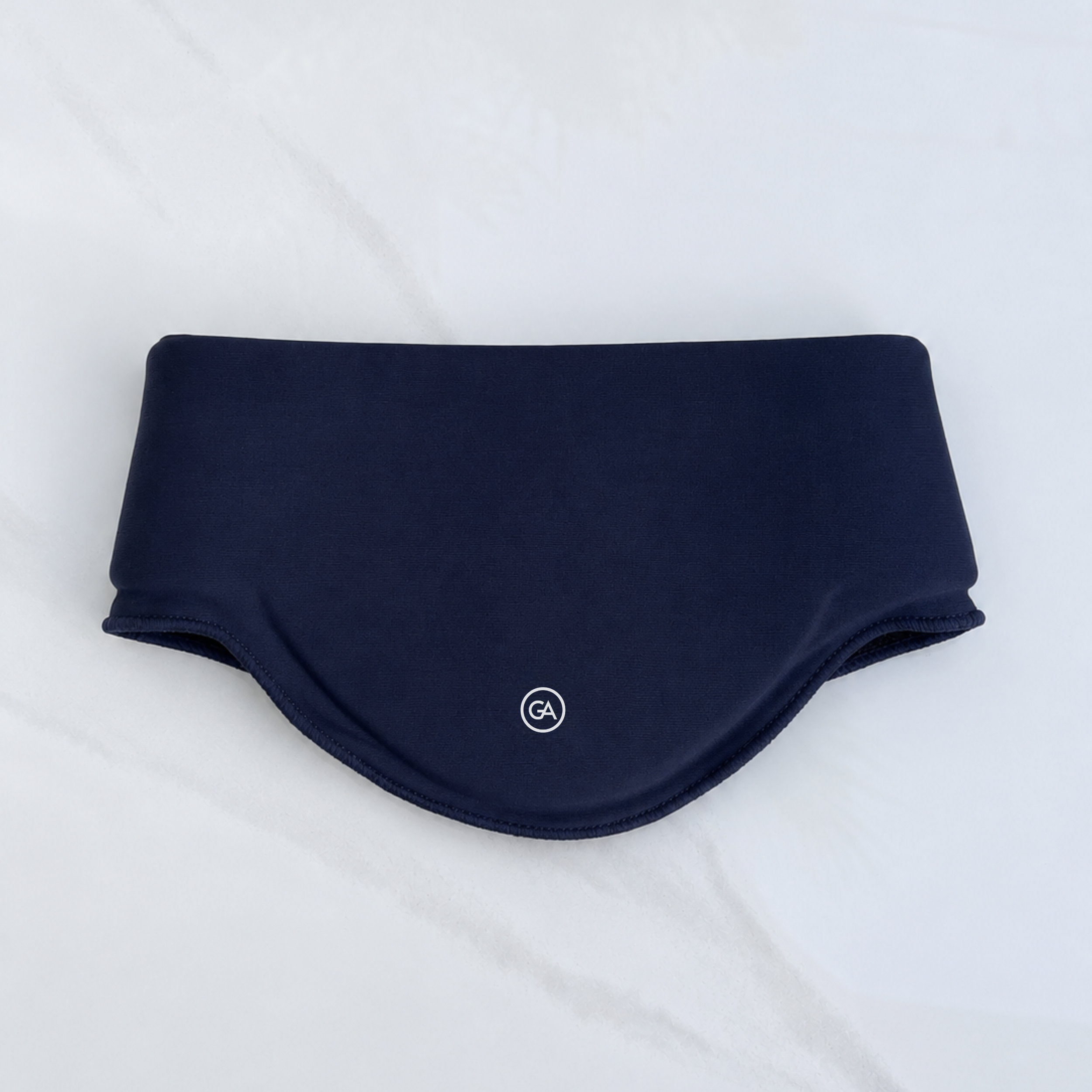 A midnight blue cooling neck wrap laid flat on a light gray marble-textured background.