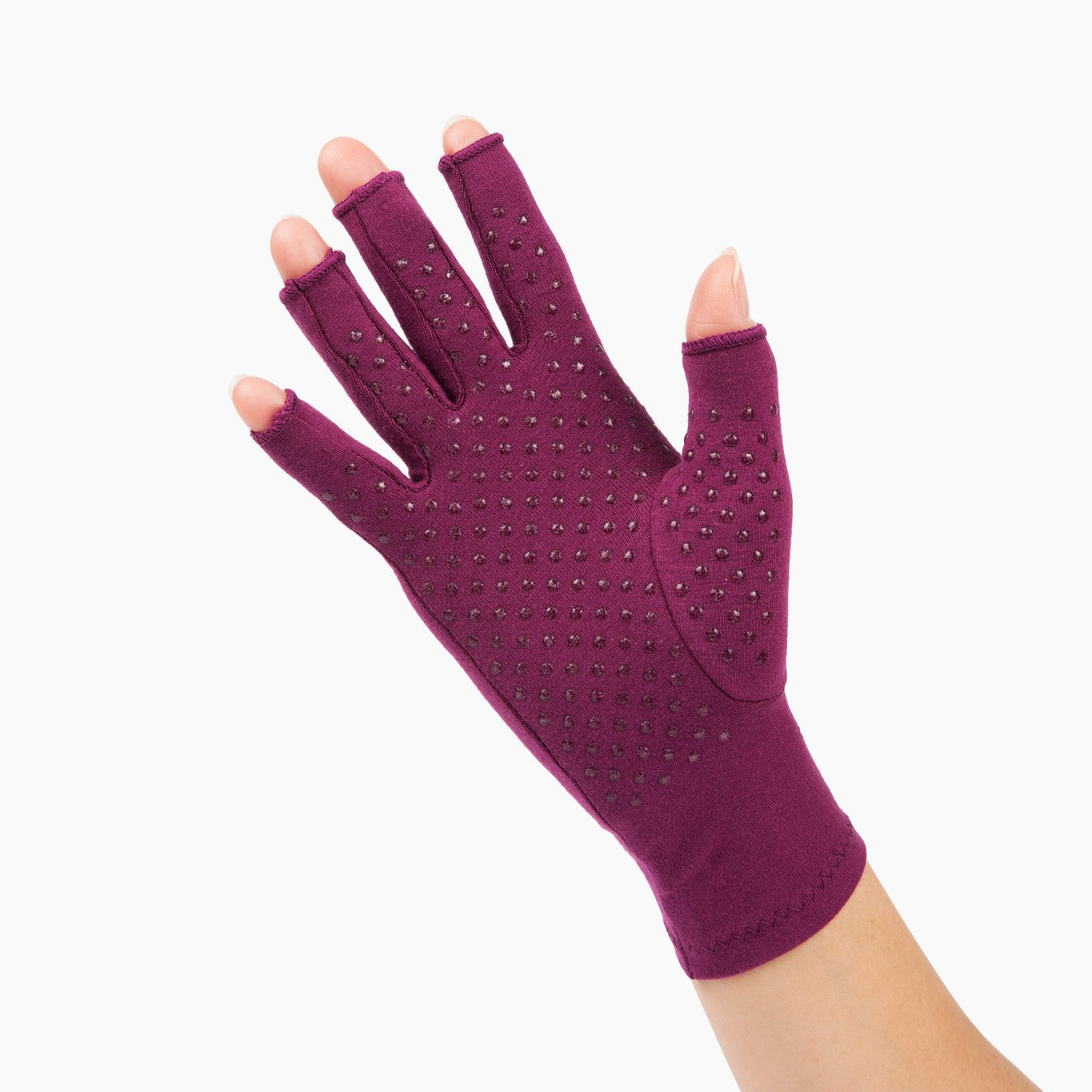 plum purple compression gloves with silicone dots on palm worn by a hand with arthritis waving on a white background