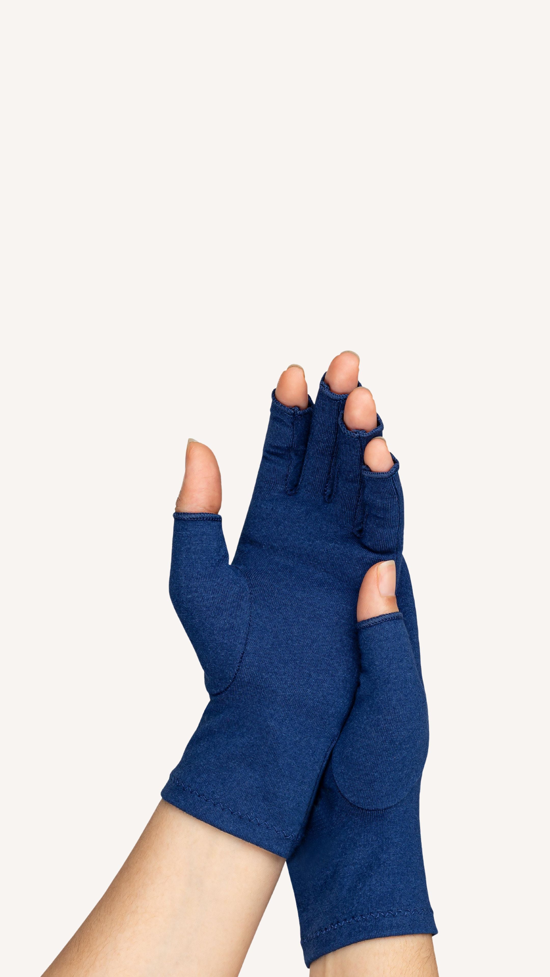 A woman with arthritis wearing Marine Blue Compression Gloves. Her hands are crossed with palms to the front.