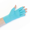 A close up of the hand of a woman with arthritis, wearing Aqua Blue Compression Gloves and showing the palm of her hand.