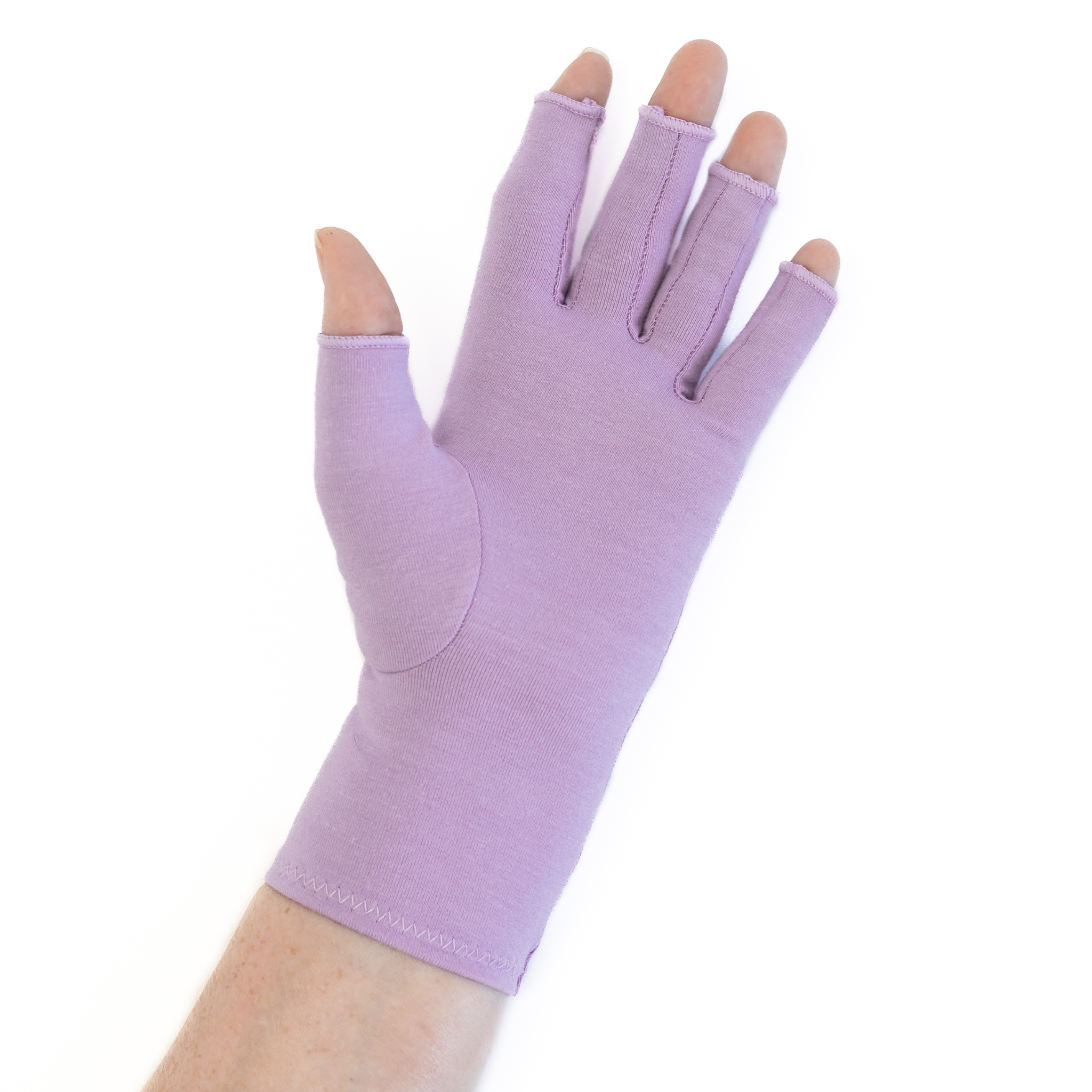 A close up of the hand of a woman with arthritis, wearing Dusky Lilac Compression Gloves and showing the palm of her hand.