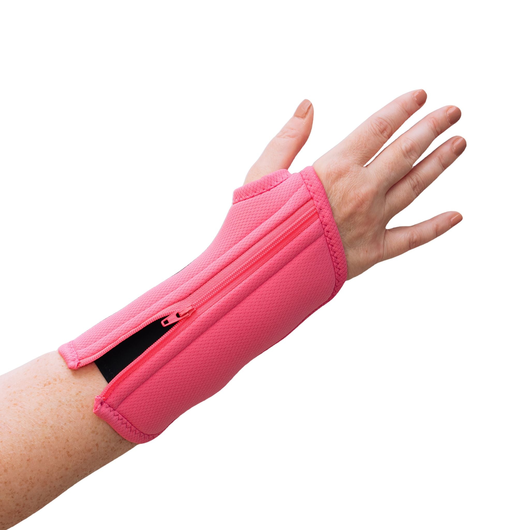 In a close-up, a woman with arthritis is showing her hand with a slightly unzipped Bubblegum Pink Wrist Brace. The background is white.
