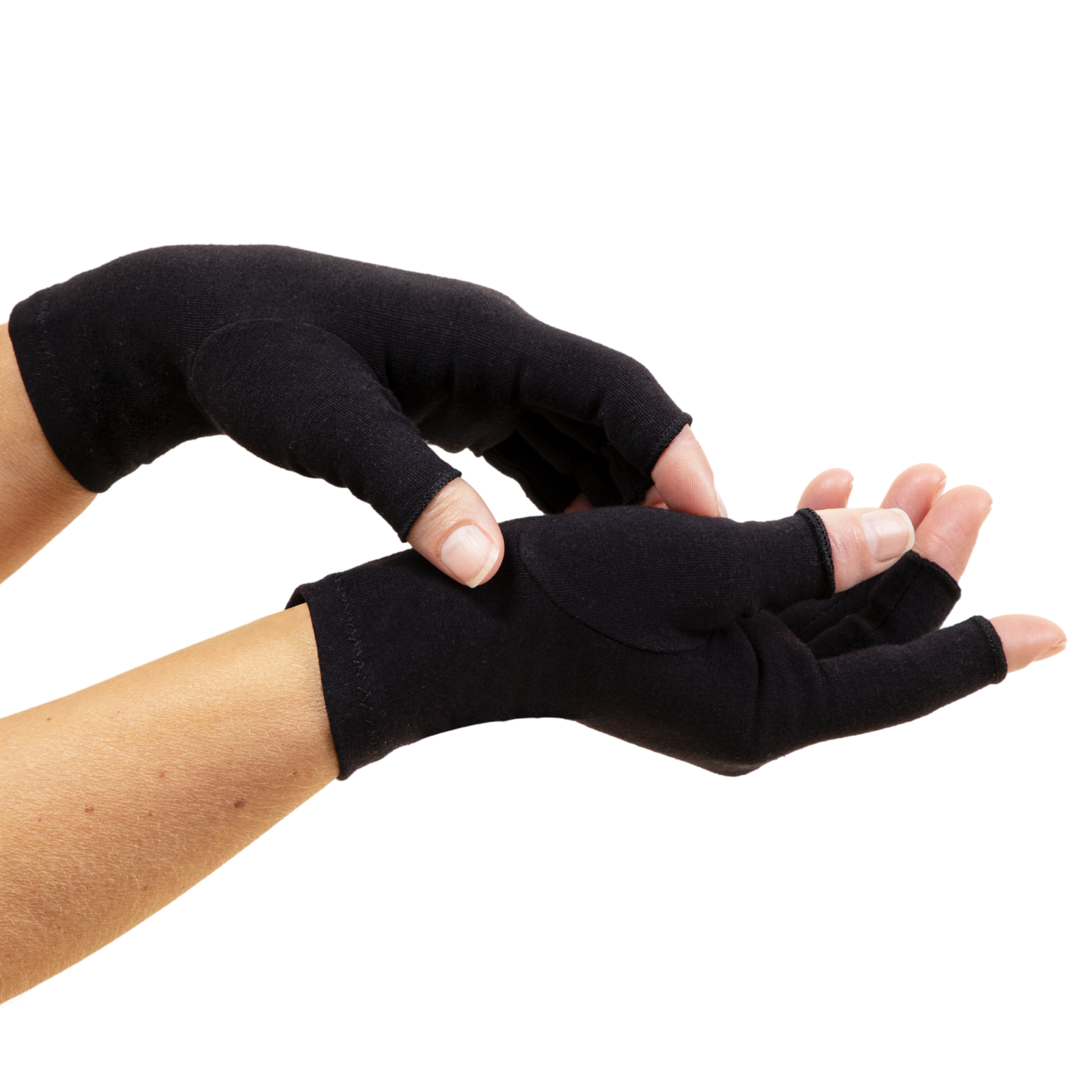 A close-up of hands of a woman with arthritis, wearing Classic Black Compression Gloves. One hand is positioned palm up, while the other hand touches it from above. The background is white.
