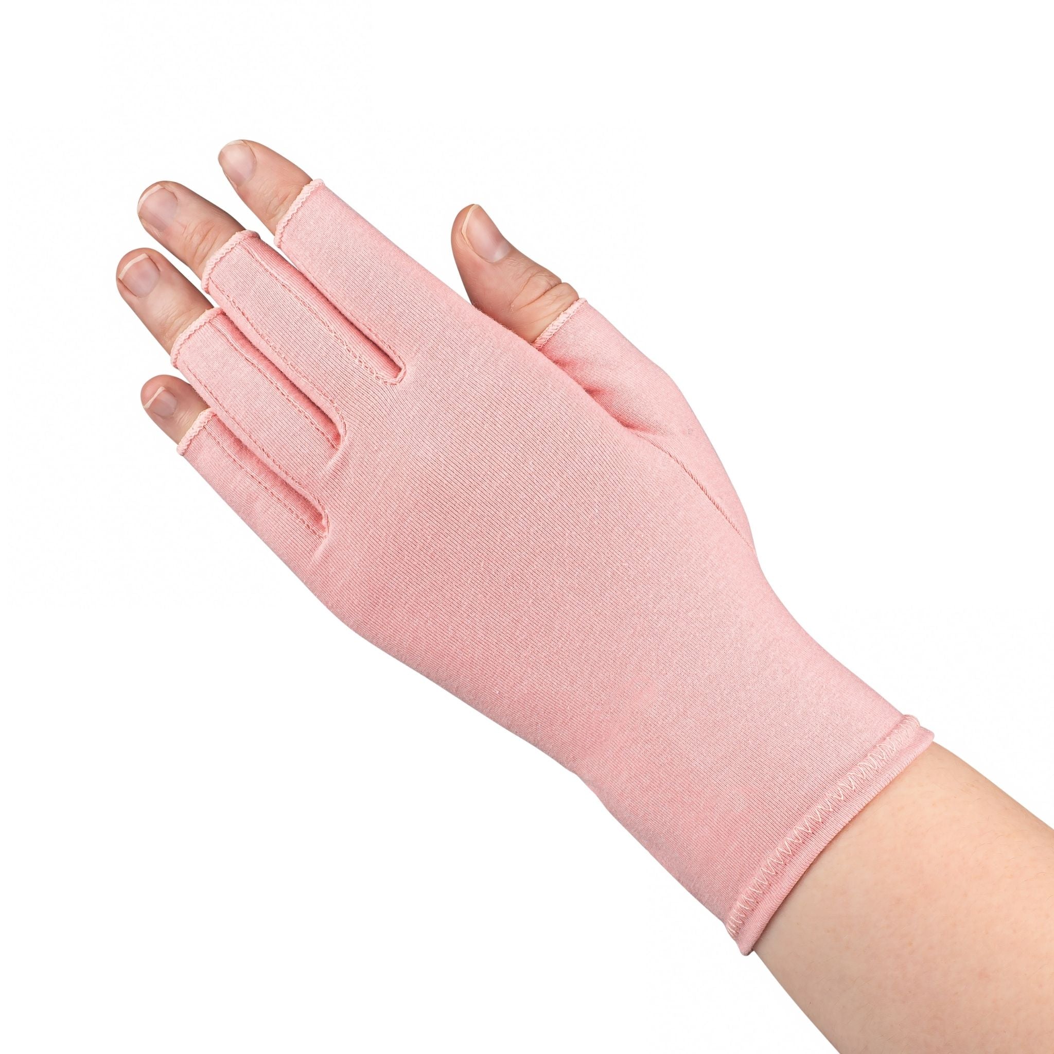 A close up of the hand of a woman with arthritis,  wearing Ballet Pink Compression Gloves and showing the back of her hand.